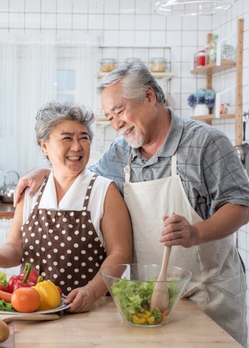 Couple joyfully cooking healthy meal